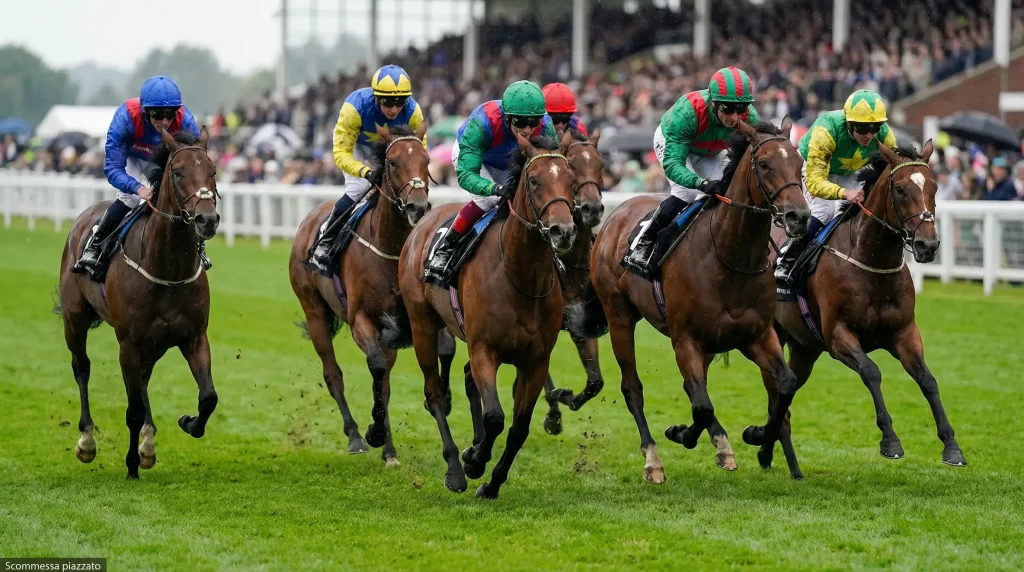 Gruppo di cavalli sul rettilineo finale di una corsa ippica su pista in erba